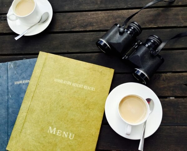 Menu sobre a mesa, duas xícaras e um binóculo